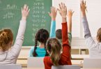 Grupa učenika s podignutim rukama u učionici tijekom nastave