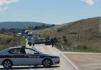 Policijski automobil i službeni timovi na mjestu prometne nesreće s vozilom izvan ceste
