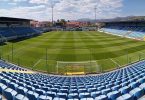 Stadion Pecara s zelenim terenom i plavim sjedištima, pripremljen za nogometnu utakmicu
