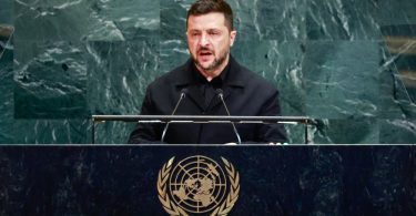Muškarac u crnom odijelu govori za govornom pultom s UN logom