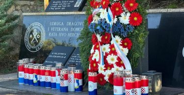 Spomen ploča s crveno-bijelim vijencem i svijećama u znamenju sjećanja
