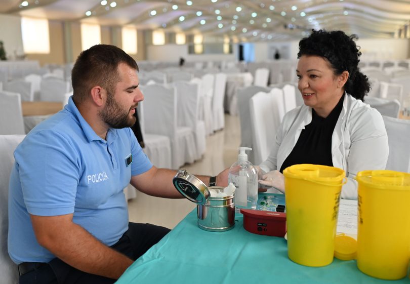 Policajac i medicinska sestra tijekom procesa darivanja krvi