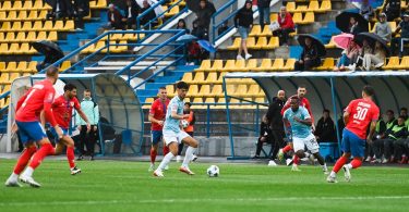 Fudbalska utakmica između Borca i Posušja, igrač u crvenoj majici driblira loptu na terenu