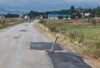Oštećena asfaltna cesta s provalijom od pukotine poklopca šahte