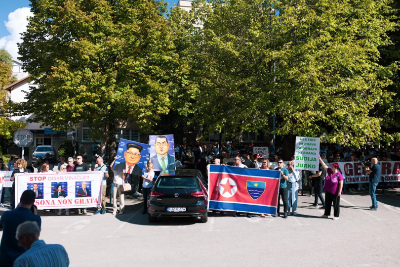 Grupa zdravstvenih radnika s transparentima prosvjeduje ispred zgrade tijekom prosvjeda