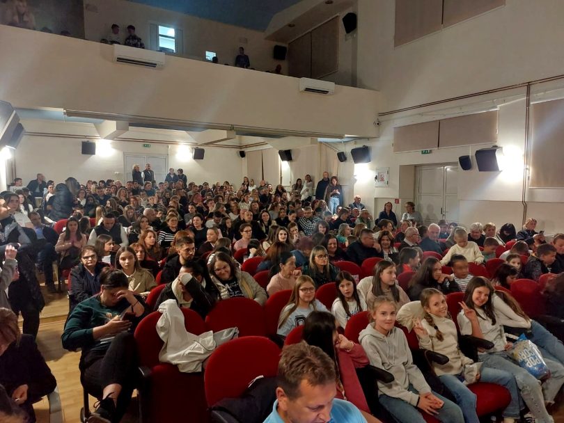 Velika skupina publike sjedita u dvorani tijekom projekcije filma