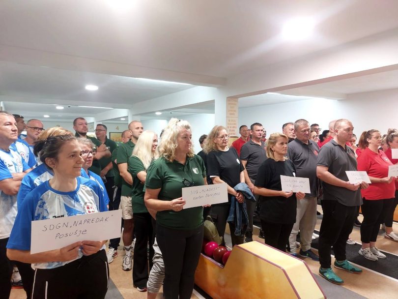 Grupa sudionika natjecanja u kuglanju drži diplome i certifikate u dvorani