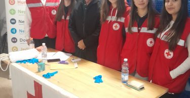 Članovi Crvenog križa pri informacijskom stolu tijekom humanitarne akcije