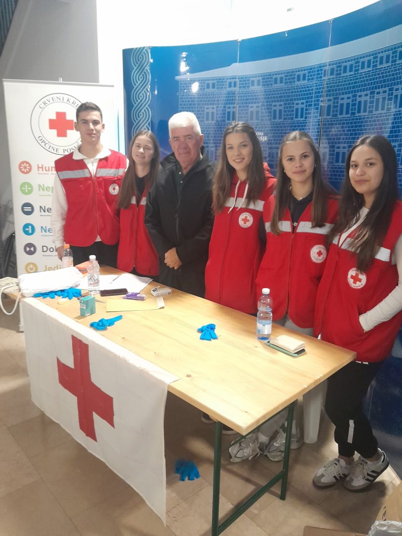 Članovi Crvenog križa pri informacijskom stolu tijekom humanitarne akcije
