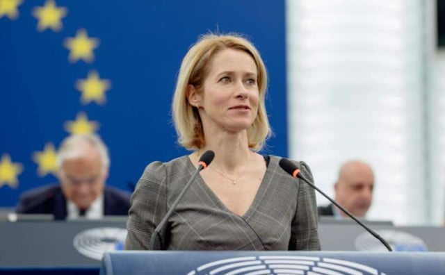 Žena govori za mikrofon pred europskom zastavom u parlamentarnoj dvorani