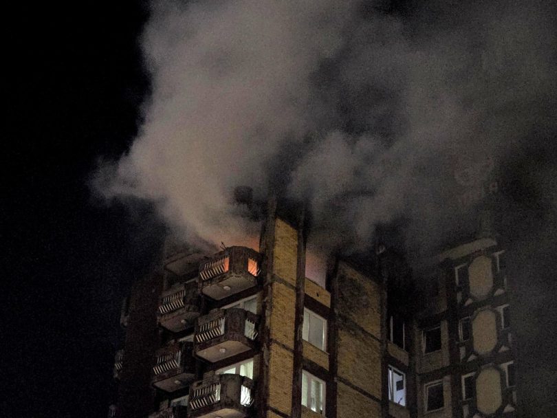 Višekatna zgrada u plamenu s gustim dimom tijekom noćnog požara