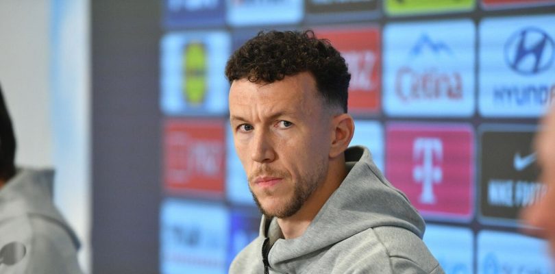 Muž u sivoj majici s kapuljačom, ozbitan izraz lica tokom intervjua