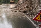 Deonica ceste blokirana odroni stijene i upozorenja znakovi, teška vremenska stanja