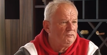 Stariji muškarac u crvenoj i sivoj jakni, emotivnog izraza lica tijekom intervjua