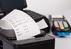 Fiskalni bon koji izlazi iz POS uređaja pored platnog terminala
