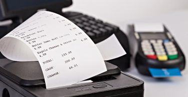 Fiskalni bon koji izlazi iz POS uređaja pored platnog terminala