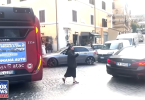 Časna sestra u crnoj odjeći regulira promet između vozila na ulici u Rimu