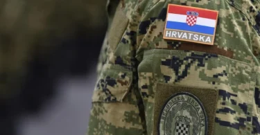 Vojnik u camuflažnoj uniformi s hrvatskom zastavom i grb-om Hrvatske vojske