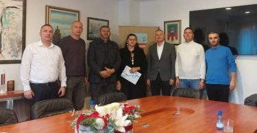 Grupa ljudi na sastanku u uredu, članova udruge i službenih osoba za akciju pomoći