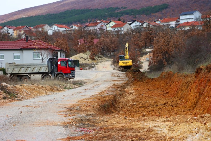 Bager i kamion na gradilištu tijekom radova u zemljanom terenu uz stambene kuće