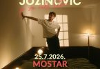 Pjevač Jakov Jozinović u pozama tijekom nastupa, ambijentalna rasvjeta u pozadini