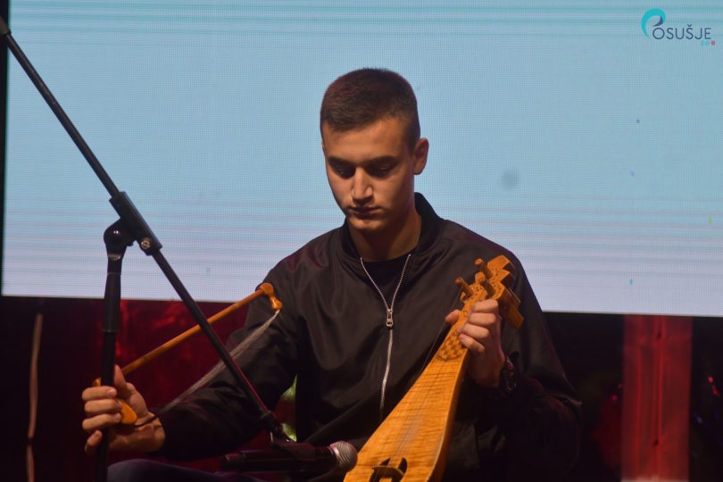Muškarca s gitarom tijekom večerneg nastupa na blagdanskoj manifestaciji