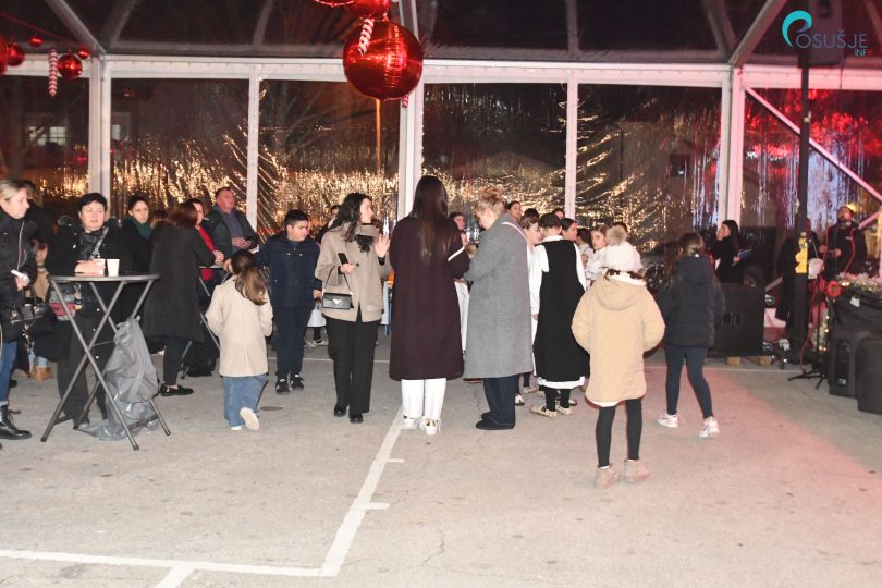 Okupljeni građani na blagdanskoj večeri tijekom prve noći Božića u Posušju 2025.