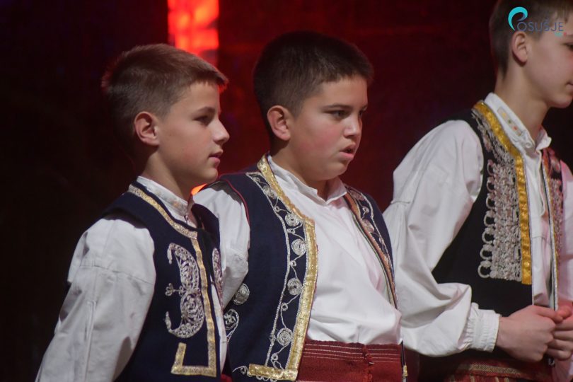 Tri dječaka u tradicionalnoj bosanskoj nošnji s vezenim detaljima tijekom blagdanske manifestacije.