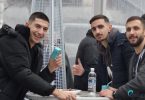 Tri mladića se smiju i poziraju za fotografiju tijekom Badnjaka