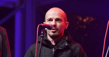 Član klape Grga pjeva u mikrofon tijekom blagdanskog koncerta