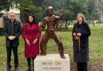 Četiri osobe pored brončane statue Bruce Leea s pločom 'Bruce Lee Tvoj Mostaf'