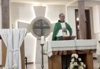 Svećenik u zelenim su ornatem pri oltaru tijekom službe Božje, pozadini križ i svijeće