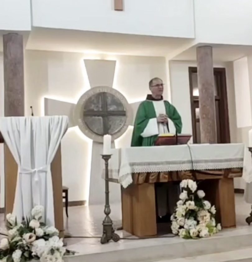Svećenik u zelenim su ornatem pri oltaru tijekom službe Božje, pozadini križ i svijeće