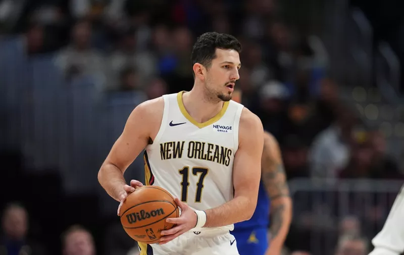 Košarkaš u dresu New Orleans Pelicansa s brojem 11 drži loptu tijekom utakmice