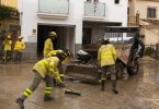 Vatrogasci u žutim odjelima čiste ulicu od šuta nakon poplava