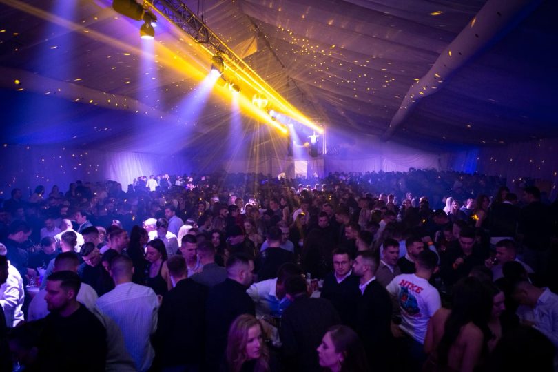 Velika scena s plavim i žutim svjetlima ispunjena gostima tijekom zimskog festivala