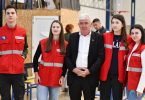 Grupa ljudi u crvenimalth uniformama i službenik poziraju na akciji darivanja krvi