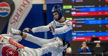 Taekwondoka u plavoj uniformi izvodi tehniku durante europskog prvenstva