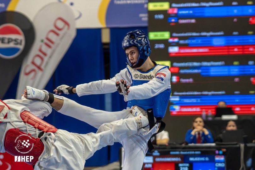Taekwondoka u plavoj uniformi izvodi tehniku durante europskog prvenstva