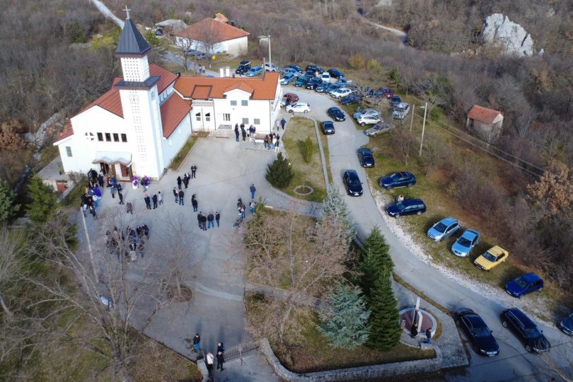 Zračni pogled na crkvu i spomen-područje u Izbičnu s prikupljenim ljudima tijekom ceremonijalnog otkrivanja