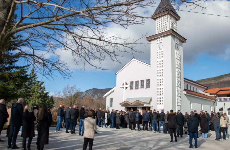 Okupljeni ljudi pred crkvom s tornjem tijekom ceremonije otkrivanja spomen-ploče