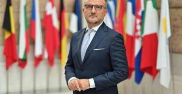 Muškarac u plavom odijelu i naočalama ispred zastava europskih zemalja