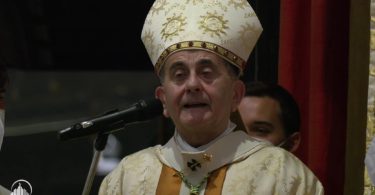 Rimokatolički nadbiskup u bijeloj mitri i liturgijskom ornatu govori na javnoj priredbi