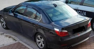 Crno policijsko vozilo s oznakama MUP ŽZH parkiran na cesti