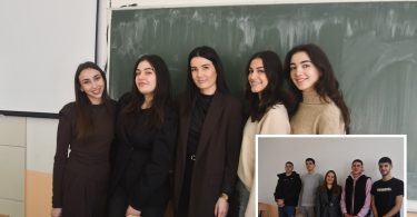 Grupa učenika u crnoj odjeći stoji ispred školske table tokom praktične nastave
