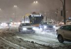 Autobusi i automobili zarobljeni u snježnoj oluji na cesti tijekom noći s uključenim svjetlima