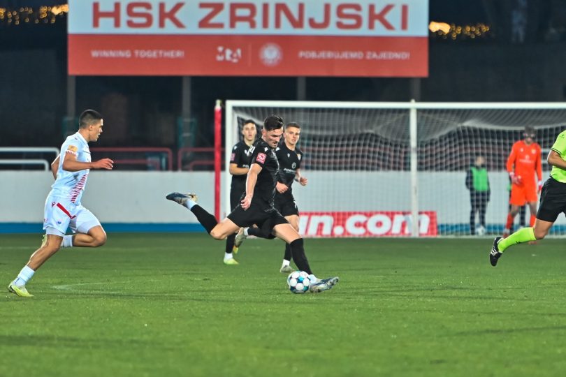 Fudbalska akcija tijekom utakmice HŠK Posušje, igrač u crnom dresa s loptom pred golmanom protivnika