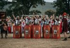 Rimski vojnici u crvenim uniformama i oklopima sa štitovima tijekom Rimskih dana u Mokrom