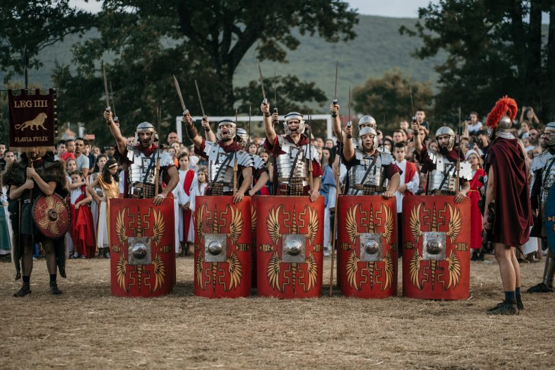 Rimski vojnici u crvenim uniformama i oklopima sa štitovima tijekom Rimskih dana u Mokrom