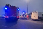 Vozila hitne pomoći i vatrogasci na mjestu nesreće noću, s migrantima i osobama u intervenciji